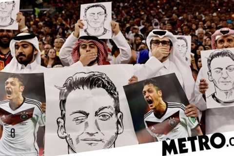 World Cup fans in Qatar hold up Mesut Ozil pictures at Germany players during Spain clash | Football